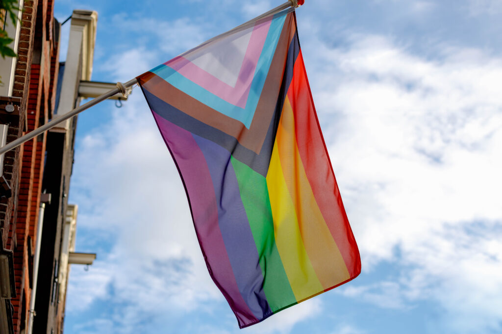 Equality Pride Flag flies in front of a blue sky